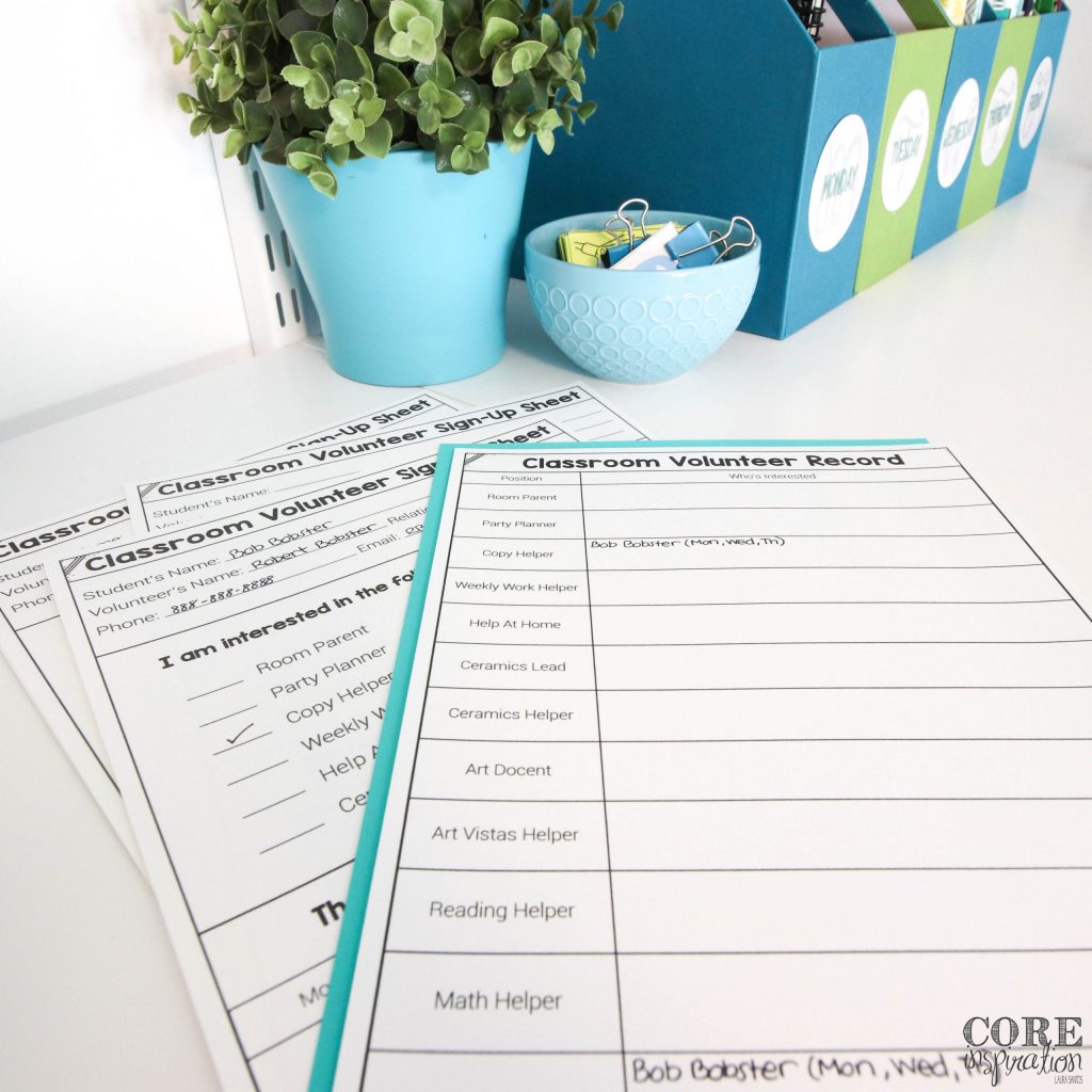 A sheet titled "Classroom Volunteer Record" laying on the teacher's desk next to several sign up sheets that have been completed by parents to show their interest in volunteering in the classroom.