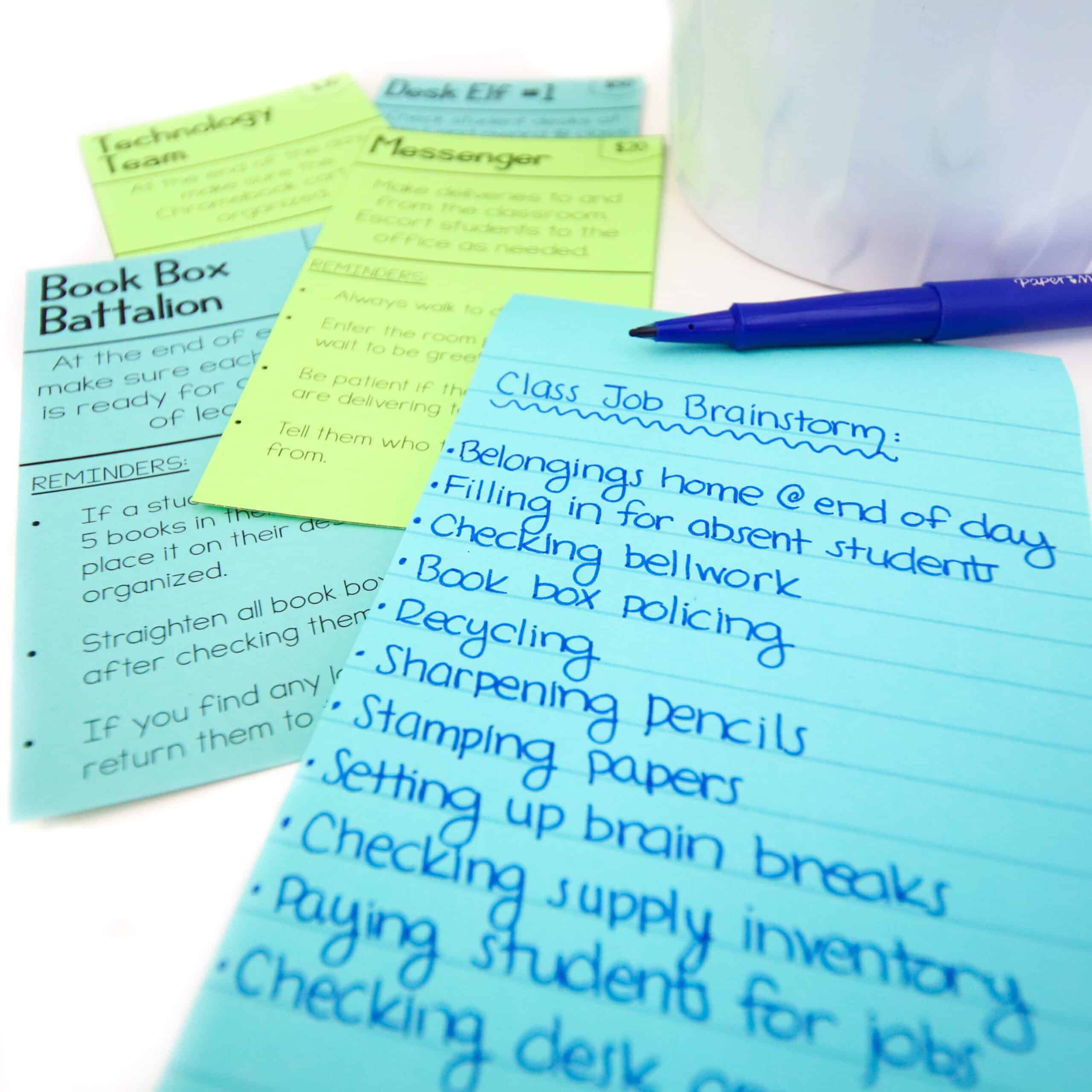 Classroom job brainstorming is written on a blue post it note next to a collection of classroom job cards. 